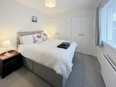 a bedroom with a bed with white sheets and a window at Kiloran in Oban