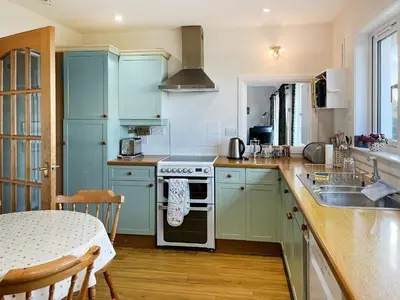 a kitchen with blue cabinets and a stove top oven at Kiloran in Oban