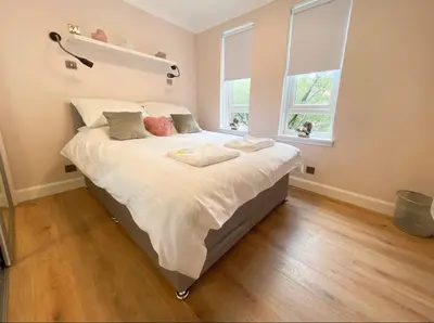 a bedroom with a large bed with white sheets and pillows at Central two bedroom, Free private parking in Glasgow