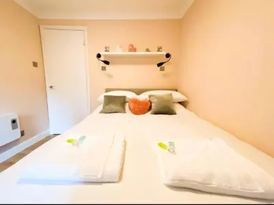 a small bedroom with a bed with two pillows at Central two bedroom, Free private parking in Glasgow