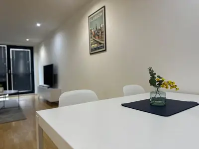 a white table with a vase of flowers on it at Glasgow River Clyde Hydro Aprt in Glasgow