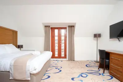 a hotel room with a bed and a desk and a television at Kelpies Hotel Falkirk in Falkirk