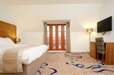 a bedroom with a bed and a flat screen tv at Kelpies Hotel Falkirk in Falkirk
