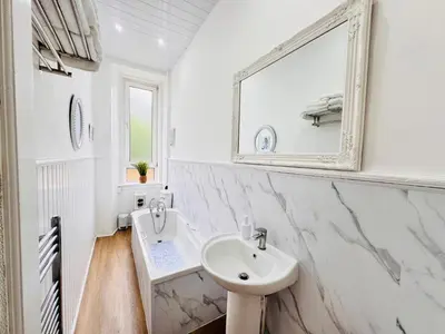 a white bathroom with a sink and a mirror at THE RESTING LION - Gourock Town Center Holiday Home Apartment in Gourock