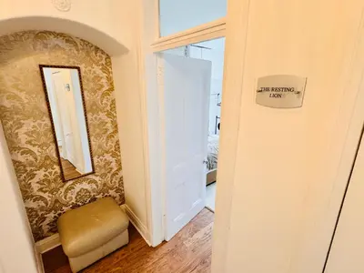 a room with a door and a stool and a mirror at THE RESTING LION - Gourock Town Center Holiday Home Apartment in Gourock