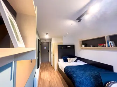 a small bedroom with two beds and a shelf at For Students Only Portsburgh Court Edinburgh in Edinburgh
