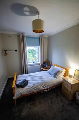 a bedroom with a bed and a window at Spacious 4-Bedroom House in Glenboig in Glenboig