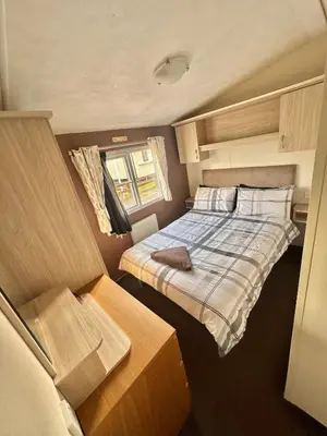 a small bedroom with a bed and a window at Delta, Bromley 4-Bedroom Located in Uddingston, Glasgow at Maryville Caravan Site in Uddingston