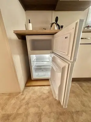 an empty refrigerator with its door open in a kitchen at Delta, Bromley 4-Bedroom Located in Uddingston, Glasgow at Maryville Caravan Site in Uddingston
