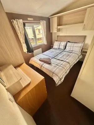 a small bedroom with a bed and a window at Delta, Bromley 4-Bedroom Located in Uddingston, Glasgow at Maryville Caravan Site in Uddingston