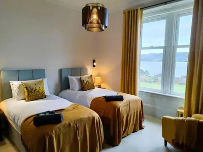 a bedroom with two beds and a large window at Bella Vista Manor - with elevated views over Rothesay & Loch Striven in Rothesay