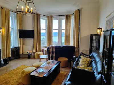 a living room with a couch and a table at Bella Vista Manor - with elevated views over Rothesay & Loch Striven in Rothesay