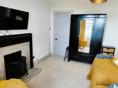 a living room with a fireplace and a tv at Bella Vista Manor - with elevated views over Rothesay & Loch Striven in Rothesay
