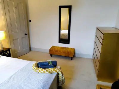 a bedroom with a bed and a dresser and a mirror at Bella Vista Manor - with elevated views over Rothesay & Loch Striven in Rothesay