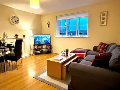 a living room with a couch and a table at Charming, Cosy Escape with Quick Access to Glasgow in Paisley