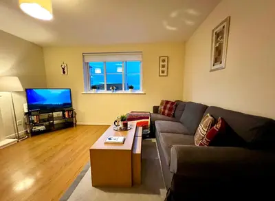 a living room with a couch and a tv at Charming, Cosy Escape with Quick Access to Glasgow in Paisley