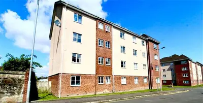 a large brick building on the side of a street at Charming, Cosy Escape with Quick Access to Glasgow in Paisley