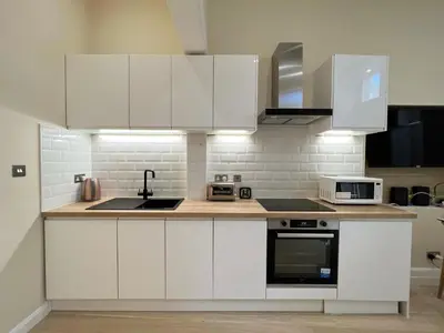 a white kitchen with white cabinets and appliances at Edinburgh city centre 1Bed flat near Castle & Uni in Edinburgh