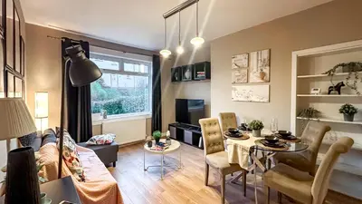 a living room with a table and a dining room at Holly street house with Separate Entrance,Glasgow edge in Clydebank