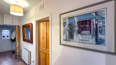 a hallway with a picture hanging on a wall at Holly street house with Separate Entrance,Glasgow edge in Clydebank