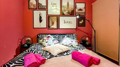 a bedroom with a bed with pink pillows and pictures at Holly street house with Separate Entrance,Glasgow edge in Clydebank