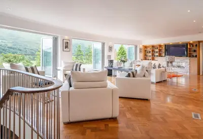 a living room with white furniture and a staircase at Invercreran House in Appin