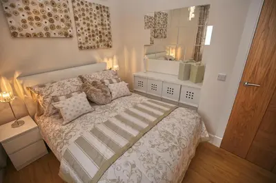 a small bedroom with a bed with a mirror at Edinburgh Pearl Apartments - Dalry House Residence in Edinburgh