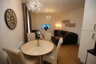 a living room with a table and a couch at Edinburgh Pearl Apartments - Dalry House Residence in Edinburgh