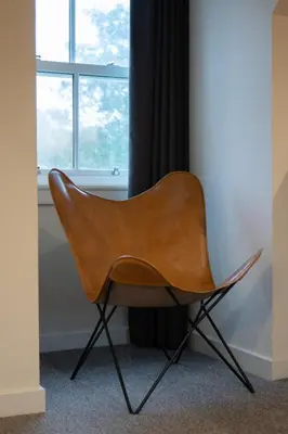 a brown chair sitting in front of a window at Taynuilt Inn Apartments in Taynuilt