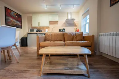 a living room with a couch and a table at Taynuilt Inn Apartments in Taynuilt