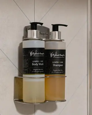 three bottles of body wash sitting on a shelf at Taynuilt Inn Apartments in Taynuilt