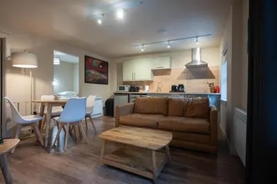 a living room and kitchen with a couch and a table at Taynuilt Inn Apartments in Taynuilt