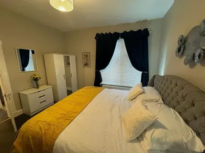 a bedroom with a large bed with a yellow blanket at Peaceful Place in Falkirk