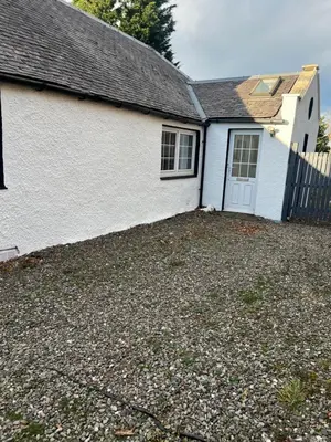 a white house with a white door and a fence at Gogarstone Cottage in EDI