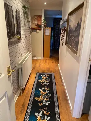 a hallway with a rug on the floor next to a door at Harbury Lodge in Scotstoun West Station