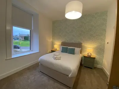 a bedroom with a large bed and a window at 1 Smithhills Sleeps 5 Central and Spacious in Paisley