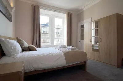 a bedroom with a large bed and a window at Modern City Centre Apartment in Central Hub in Edinburgh