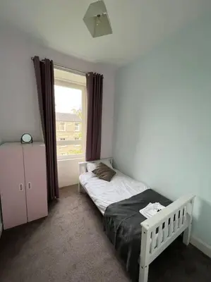 a small bedroom with a bed and a window at Modern City Centre Apartment in Central Hub in Edinburgh