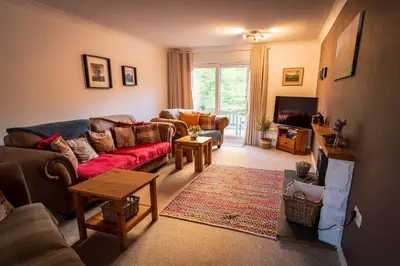 a living room with a couch and a tv at Sachsblick in Lochgoilhead