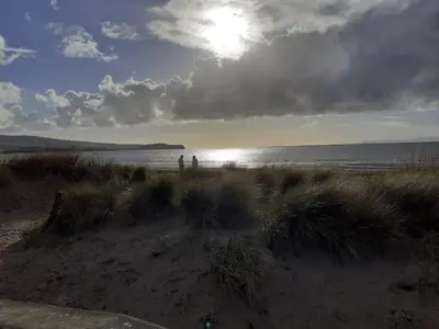 two people standing on a beach near the water at Apartment 28 in Ayr