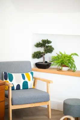 a chair with a pillow and a plant on a shelf at Modern apartment with stunning sea views near Oban in Connel