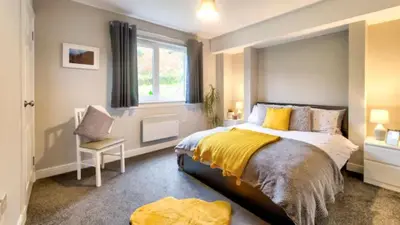 a bedroom with a large bed and a window at TheLodge in Arrochar