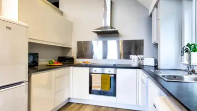 a kitchen with white cabinets and a sink at TheLodge in Arrochar