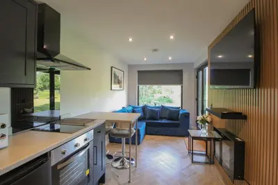a kitchen and living room with a blue couch at River Logie Lodges in Westfield