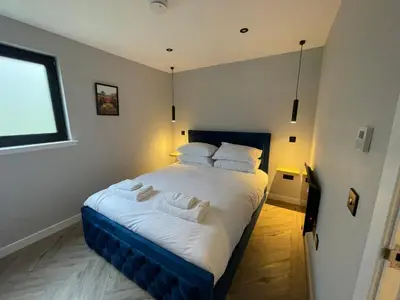 a bedroom with a large bed with white sheets and pillows at River Logie Lodges in Westfield