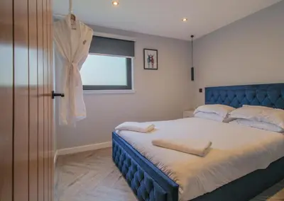 a bedroom with a blue bed and a window at River Logie Lodges in Westfield