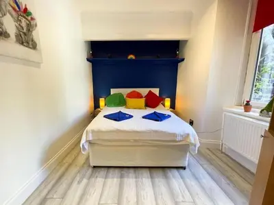 a bedroom with a bed with a blue headboard at 2 Bed apartment in city centre! in Glasgow