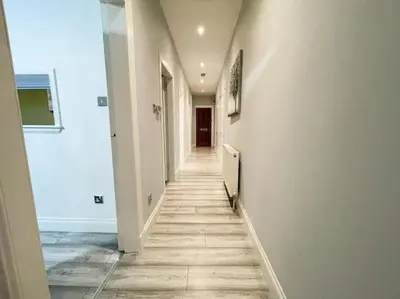 a hallway with white walls and a long hallway at 2 Bed apartment in city centre! in Glasgow
