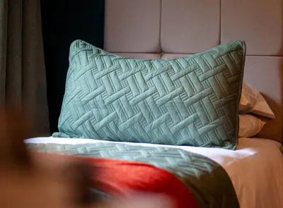 a bed with a pillow on top of it at The Corries B&B in Luss
