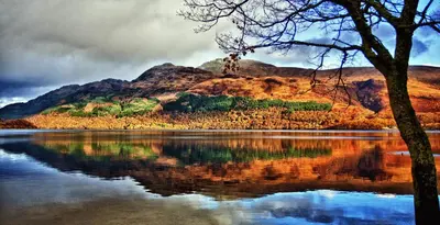 a reflection of a mountain in the water at The Corries B&B in Luss